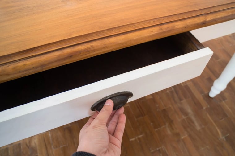 Man opening a drawer with a cup pull.